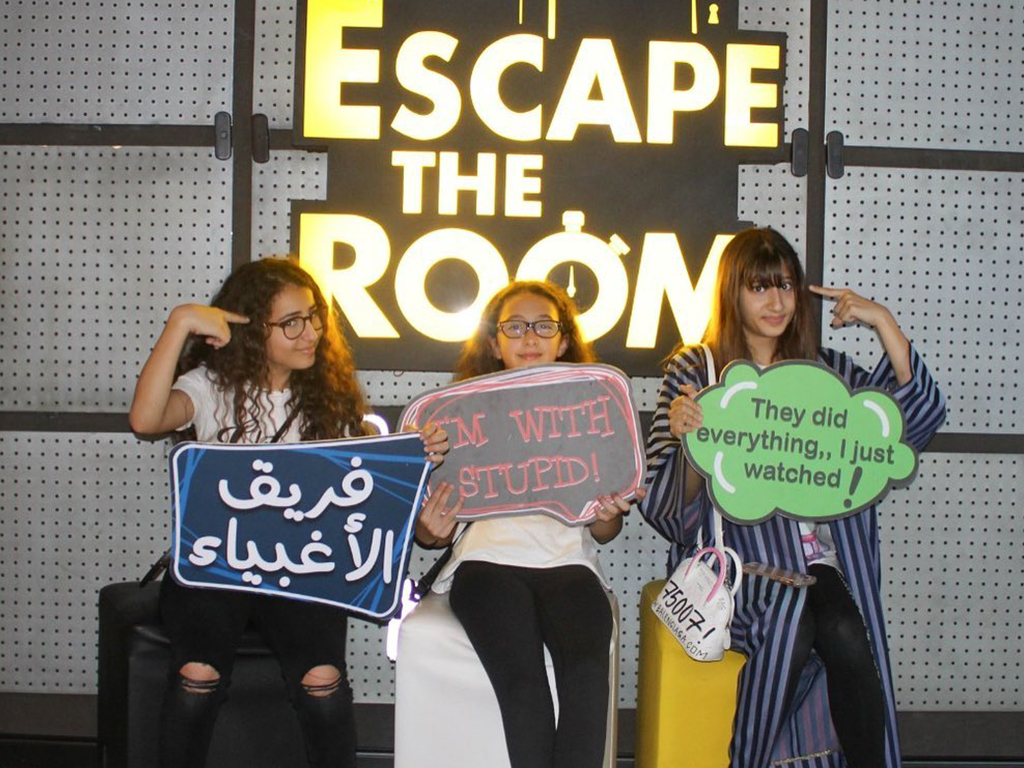 Girls holding banners at escape the room 