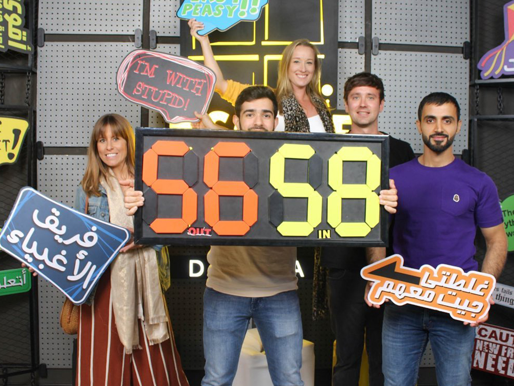 team holding banners at escape the room boxpark 